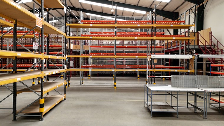 The warehouse floor with racking, the mezzanine deck beyond