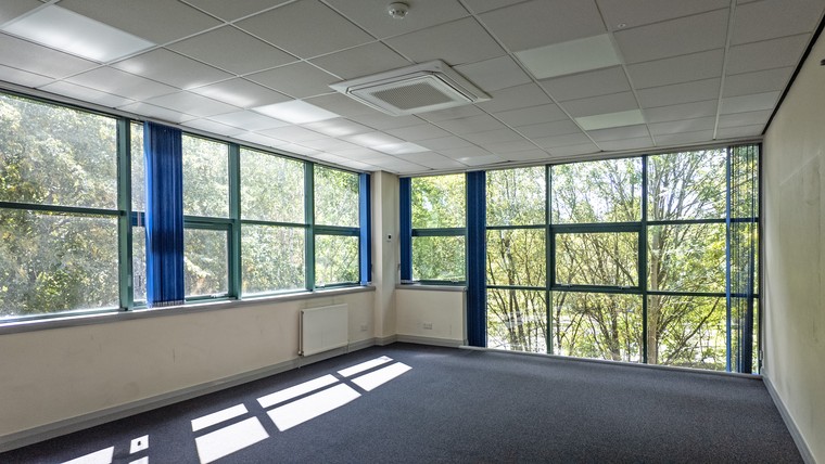 A fitted office with full height glazing overlooking trees